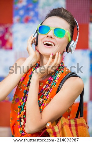 Young woman with headphones listening music .Music fashion girl  against colorful bright background. grain added