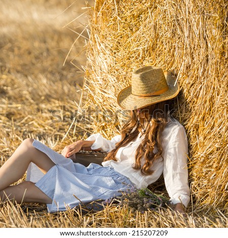 Happy girl lies on field relaxing and enjoy the nature on a summer evening. Free people concept