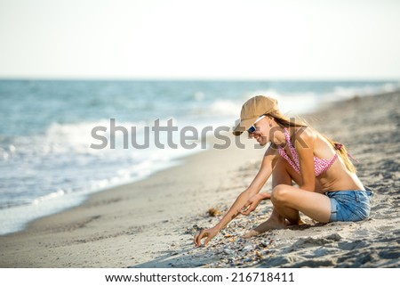 Smiling happy female model enjoying serene ocean nature during travel holidays vacation outdoors. soft backlight, grain added