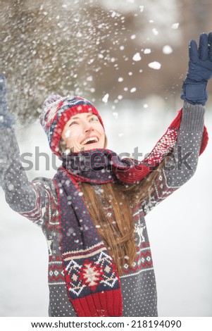 Young pretty woman having fun in the winter forest in motion