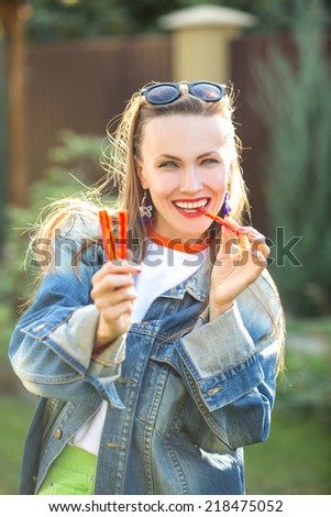 Candy woman eat sweets. Young beautiful girl eating licorice candy happy smiling.  soft backlight