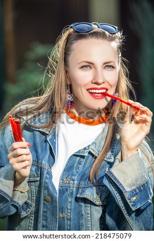 Candy woman eat sweets. Young beautiful girl eating licorice candy happy smiling.  backlight