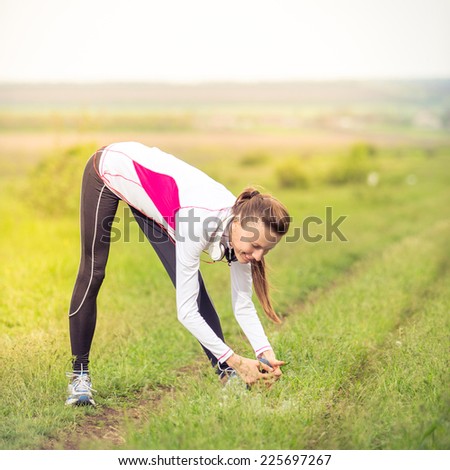 Young woman stretching before her run outdoors on a fall day