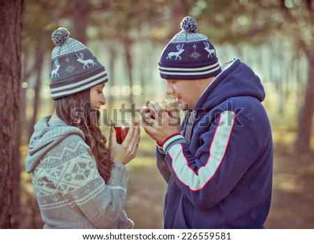 Young couple in love outdoor drinking hot tea. toned image