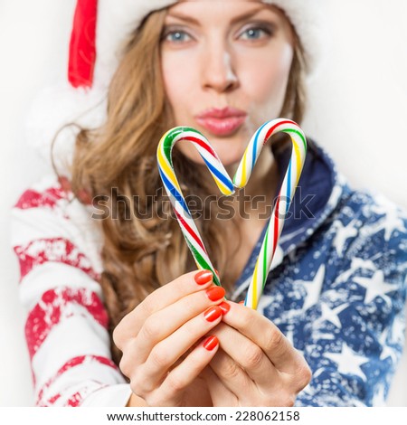 Winter heart made from candy canes holding by beautiful sexy santa woman. focus on heart and hands