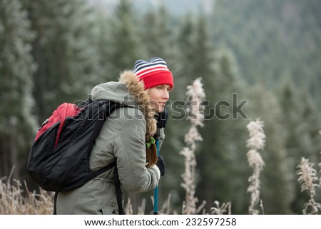 Woman with hiking equipment walking in mountain forest. daylight