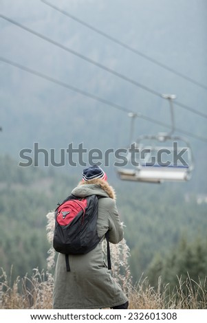 Woman, no snow and empty ski lifts on the background. daylight