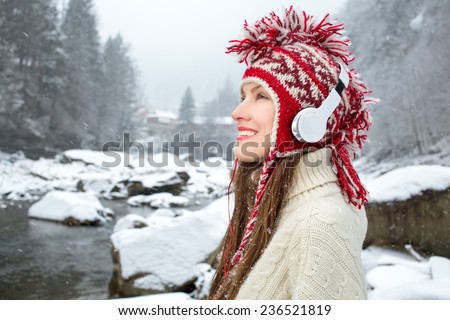 Closeup funny winter girl listening to music over snowy landscape