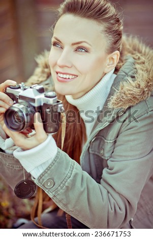 Girl with vintage retro camera. focus on face. toned image
