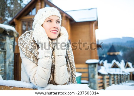 Pretty woman enjoy her winter vacation in mountain resort hold hands near face looking to the side