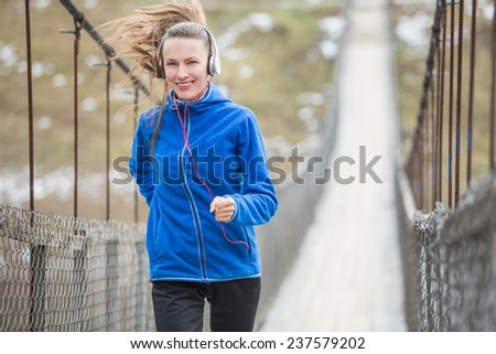Winter running woman running on old rural bridge. motion, daylight