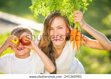 Happy mother and son with vegetables enjoy healthy eco organic food. focus on mother