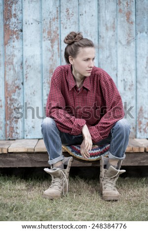 Young farmer relaxing after working over wooden background. toned pale image