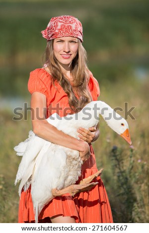 Farmer with a goose over green natural background, focus on face