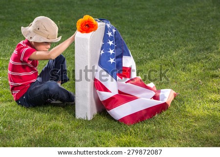 boy sitting on veterans cemetery. Memorial Day concept