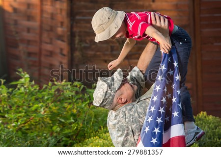 Military man father hugs son. Portrait of happy american family, daylight, shadow on boys face