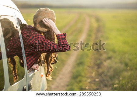 Freedom car travel concept - woman relaxing out of window in a car. Girl relaxing enjoying free holidays road trip