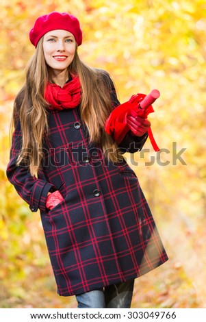 Autumn woman in autumn park with red umbrella, scarf and leather gloves