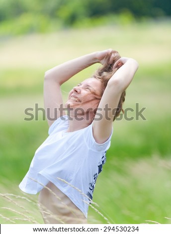 Young beautiful girl in the head stroking her hair, laughing