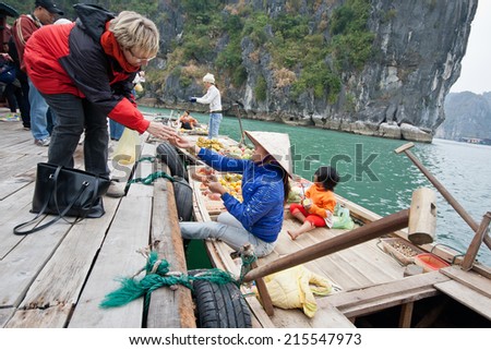 HA LONG BAY, VIETNAM - MAY 25: Unidentified woman sells fruits from her boat on Ha Long bay, Vietnam on May 25, 2014. Floating markets are very popular as it is the only way to move around.