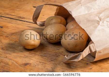 Farm fresh washed whole Potatoes in a brown paper bag