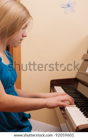 Blonde girl in blue dress playing the piano