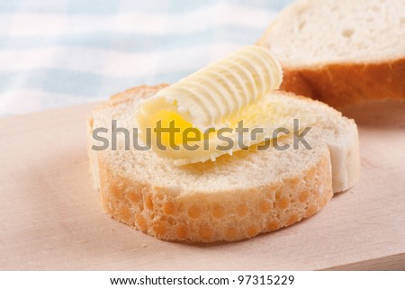 Butter curl on a slice of white bread (baguette, French bread)