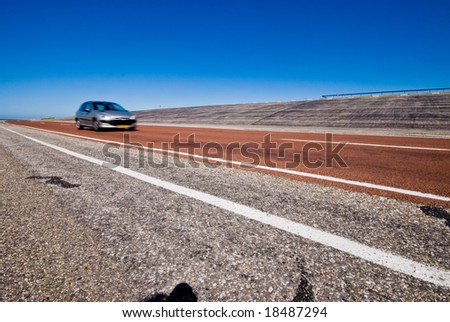 Car on wide-angle road against blue sky