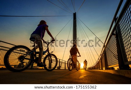 A family bicycles across the Bob Kerry pedestrian bridge over the Missouri River from Council Bluffs Iowa to Omaha Nebraska during the summer.