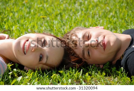 boy and girl lying outdoors enjoying the spring and each others company.