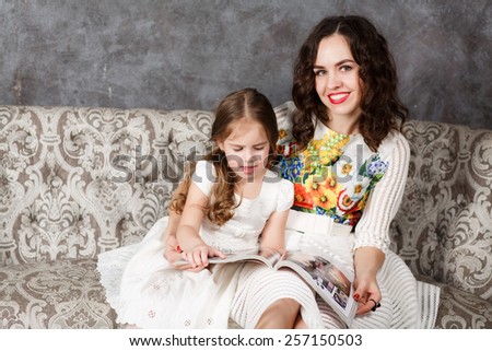Mother and daughter reading together on the couch
