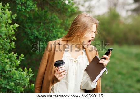 mad woman screaming on mobile phone, isolated outdoors background. Negative human face expressions, emotions, feelings, attitude