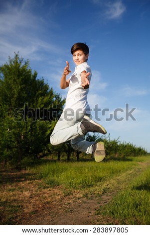 happiness, freedom, movement and people concept - smiling young man jumping