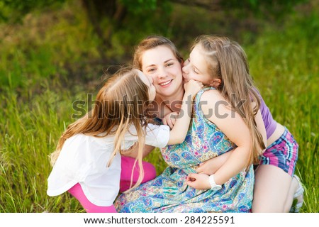 Mother's day, family, childhood and people concept - loving daughters kissing mother,
