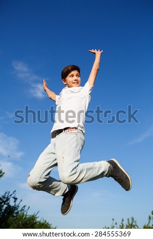 happiness, freedom, movement and people concept - smiling young man jumping