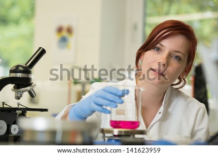 young female scientist works in laboratory wearing white coat