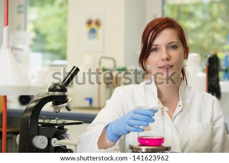 young female scientist works in laboratory wearing white coat