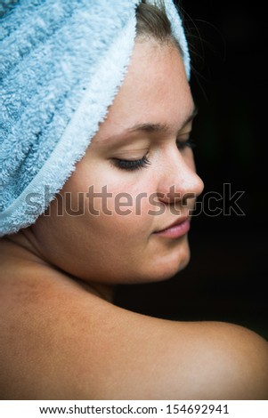 Profile of young woman  with towel wrapped around her head after taking bath