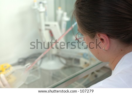 a woman works in laboratory with pipets