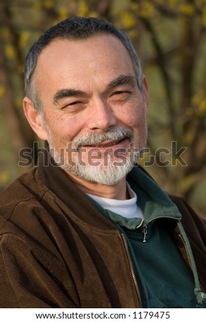 elderly man with beard in brown jacket