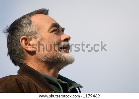 elderly man with beard in brown jacket