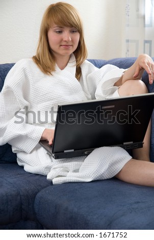 young woman in bathrobe works with laptop