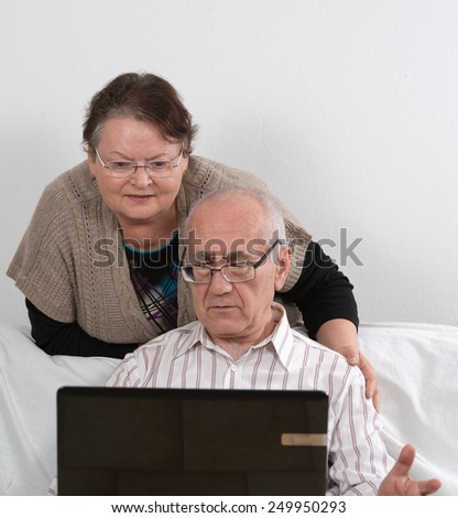 seniors couple works with laptop computer