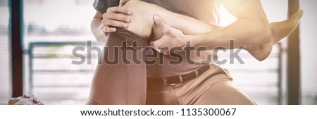Physiotherapist giving knee therapy to a woman in clinic