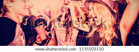 Cheerful friends dancing in nightclub