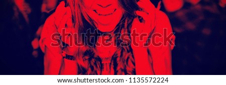 Close up portrait of cheerful woman with mouth open enjoying in nightclub