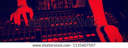 Mid section of audio engineer operating sound mixer at recording studio