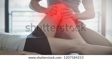 Highlighted pain against physiotherapist giving knee therapy to a woman