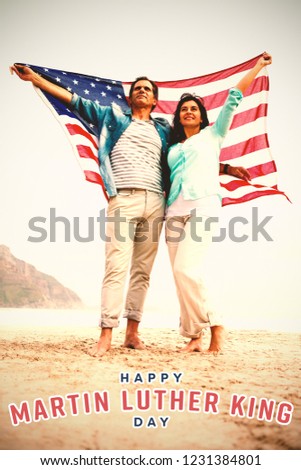 happy Martin Luther King day against full length of couple holding american flag against sky