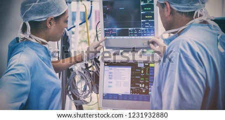 Surgeons reading computer screen in operation theater